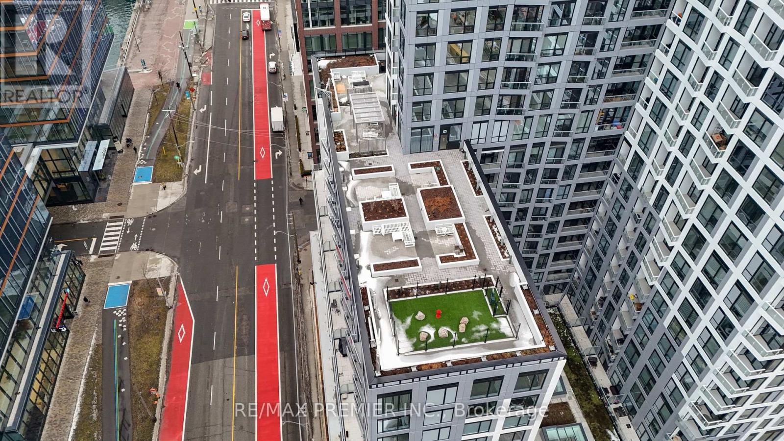 A view of a city street from above with a green space in the middle.