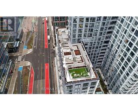 A view of a city street from above with a green space in the middle.