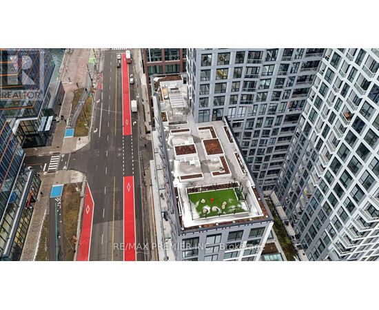 A view of a city street from above with a green space in the middle.