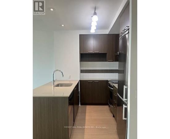 A modern kitchen with dark wood cabinets and stainless steel appliances.