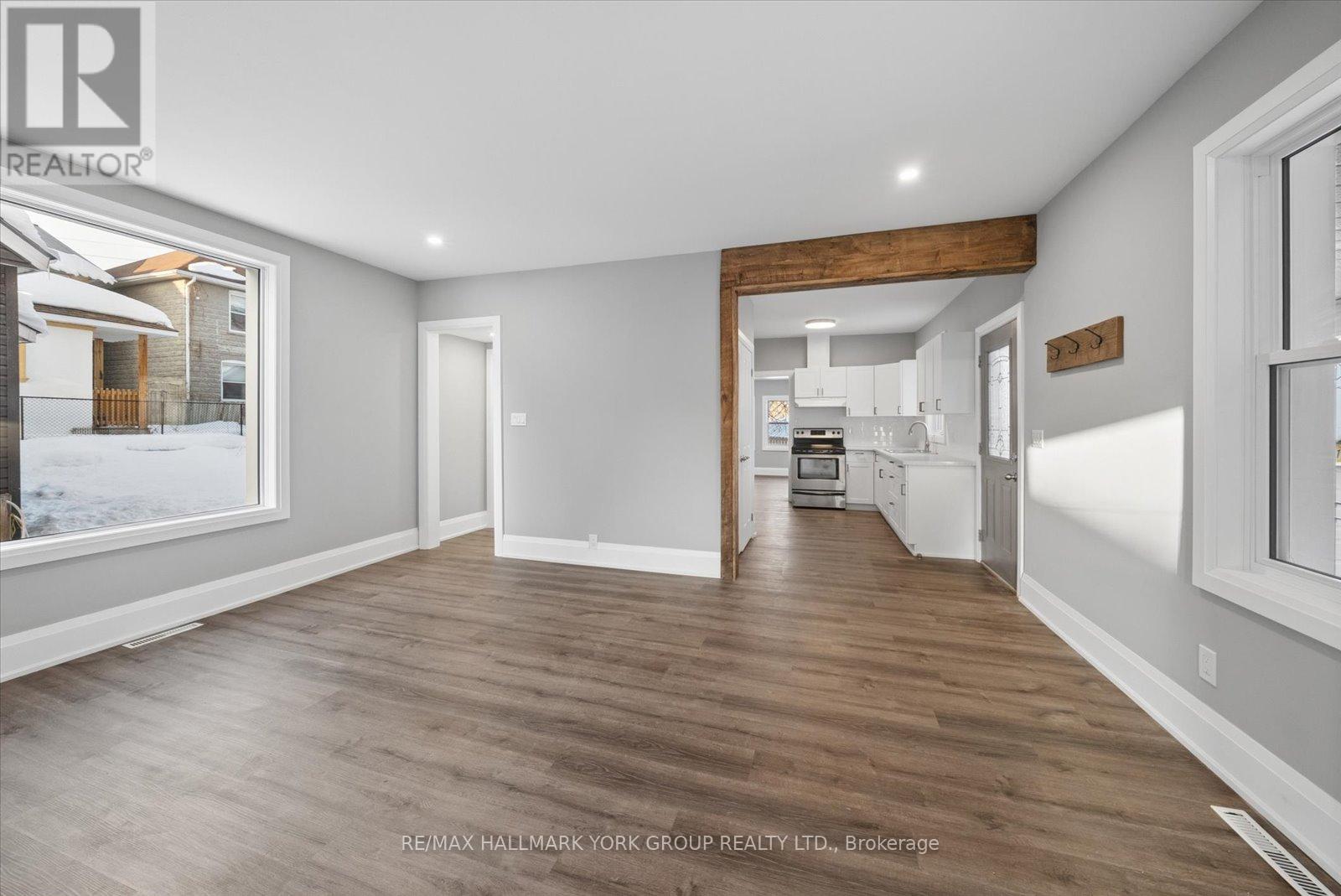 A spacious room with wooden flooring and white walls.