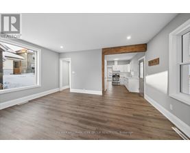 A spacious room with wooden flooring and white walls.