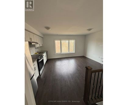 A kitchen with white appliances and wooden floors.