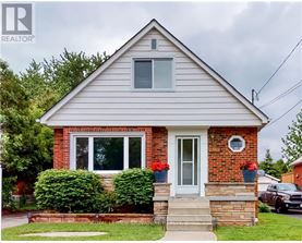 A house with a grey roof and a white door is for sale.
