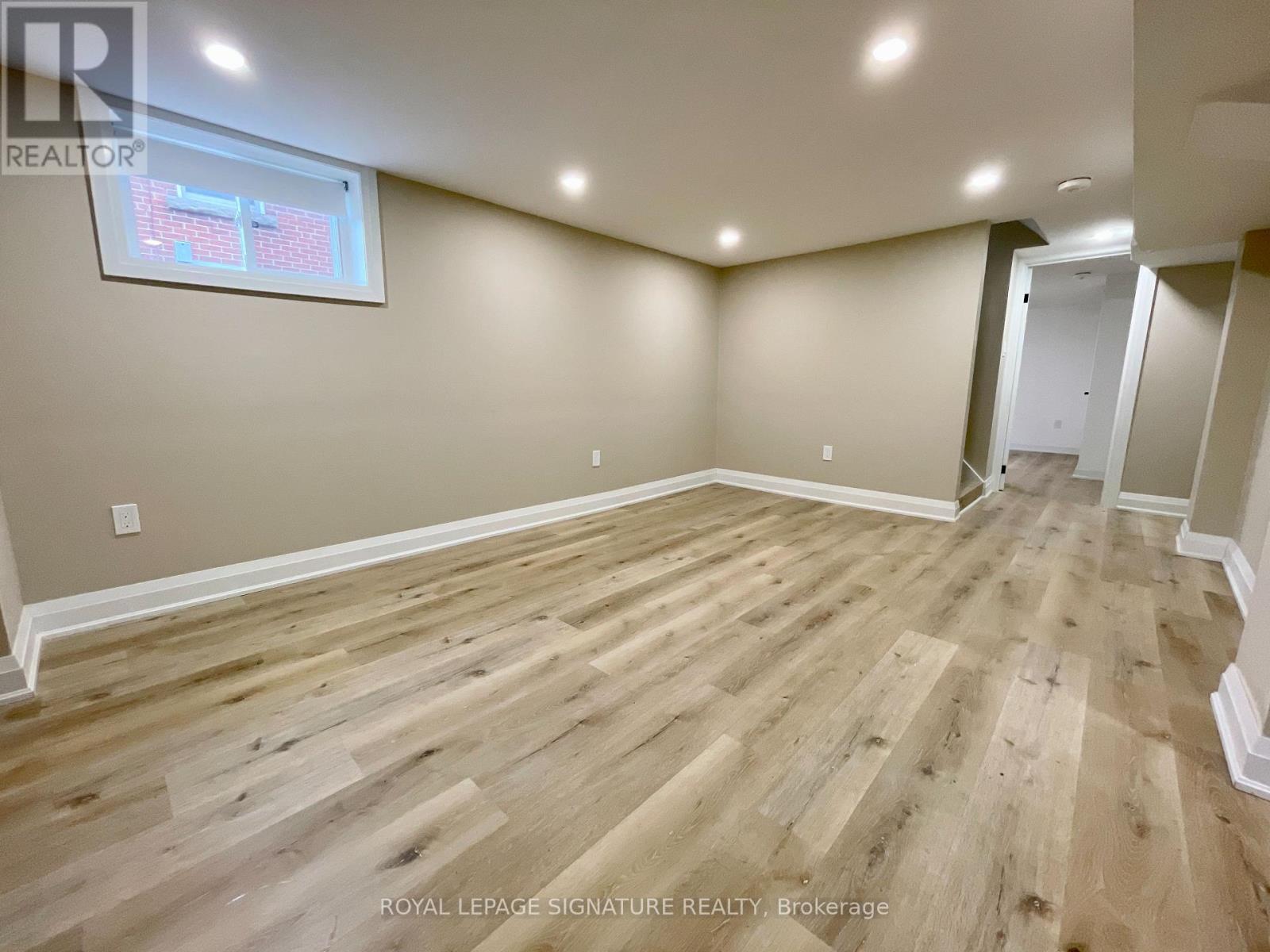 A room with wooden flooring and a window.