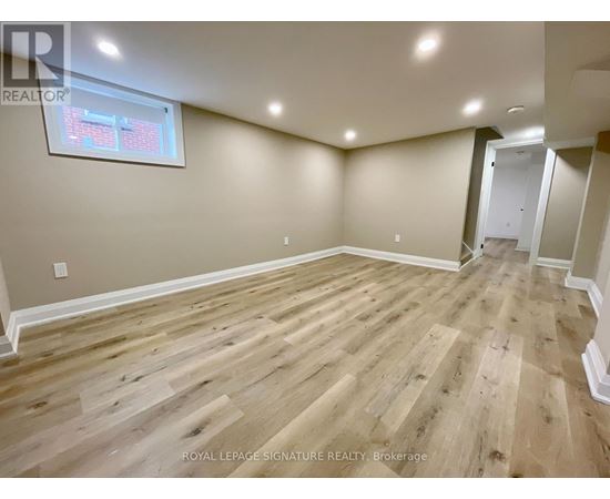 A room with wooden flooring and a window.