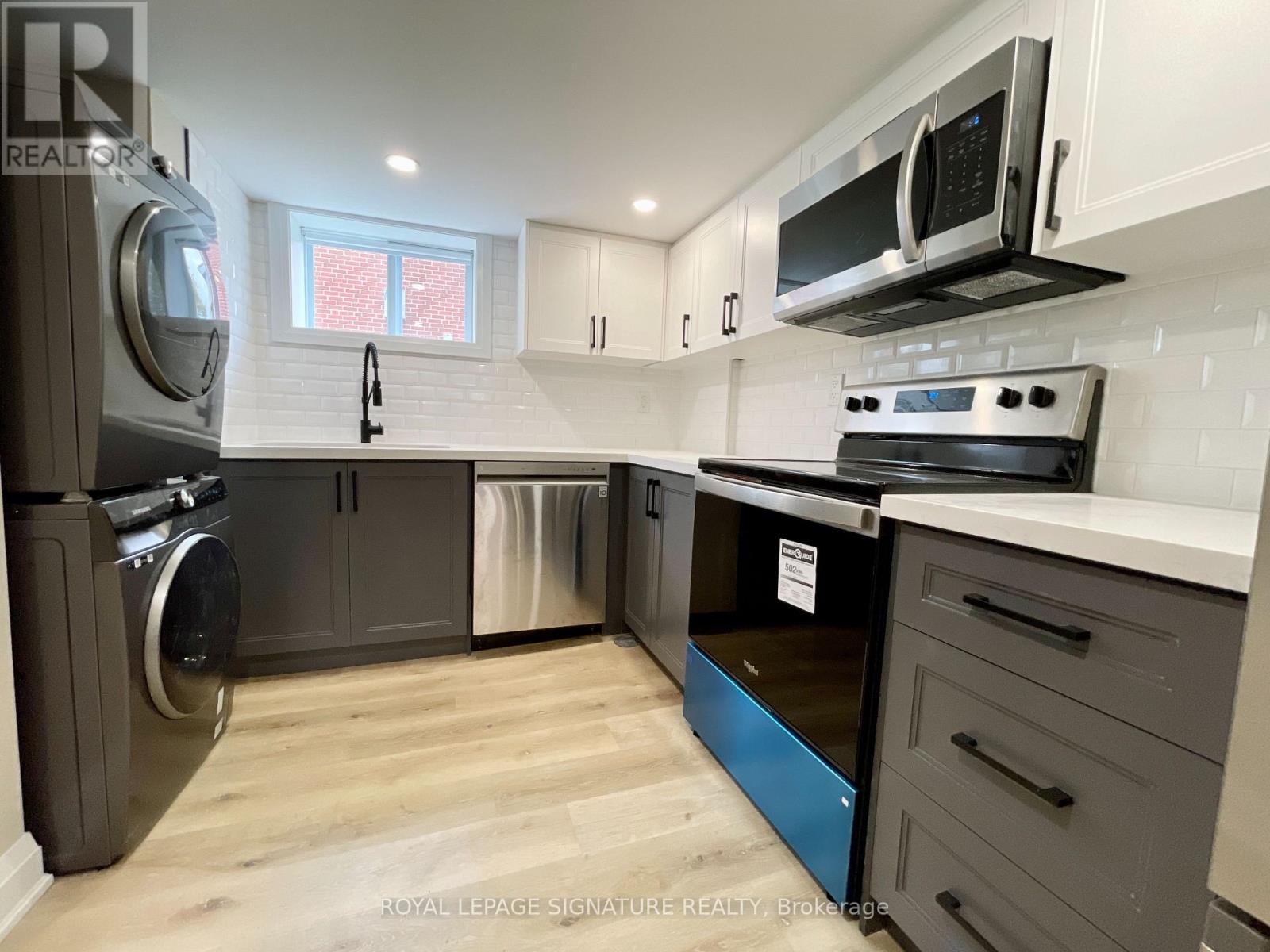 A kitchen with a stainless steel refrigerator, oven, and microwave.