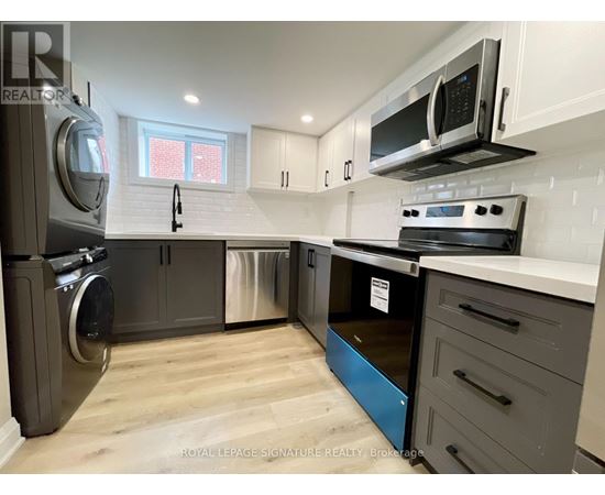 A kitchen with a stainless steel refrigerator, oven, and microwave.