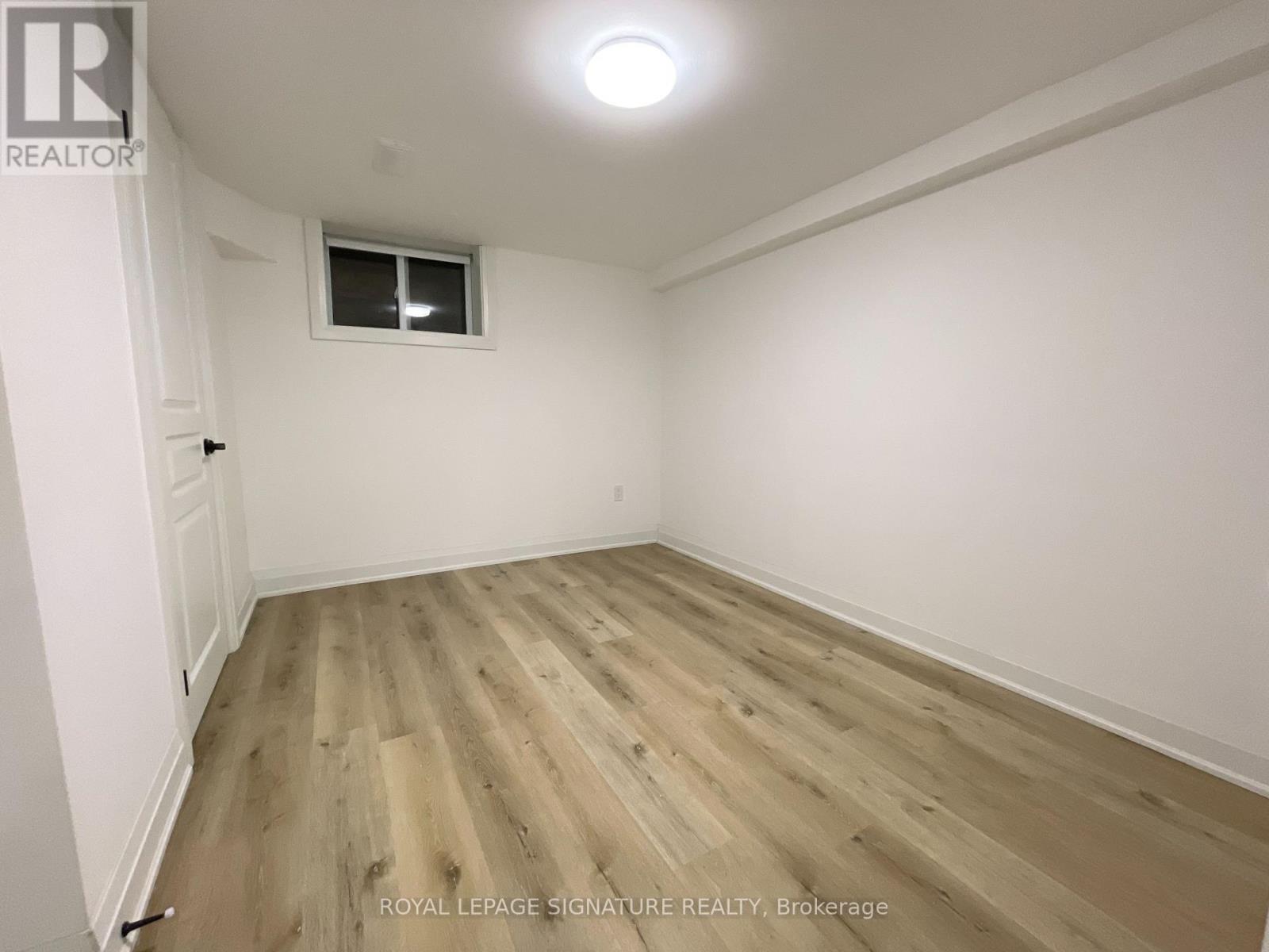 A room with wooden flooring and a window.