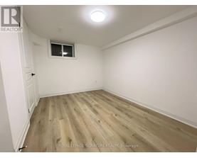 A room with wooden flooring and a window.