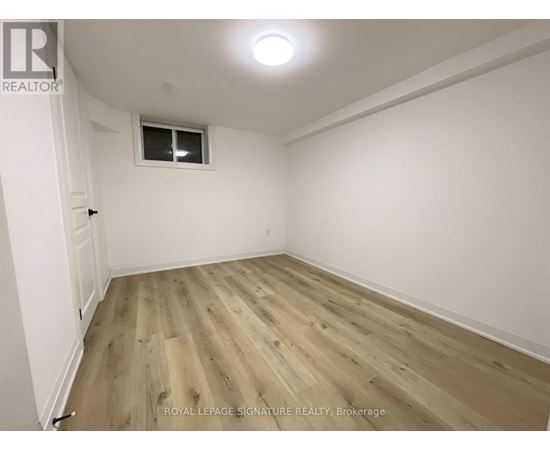 A room with wooden flooring and a window.