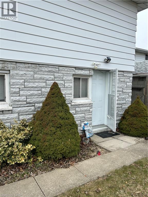 A house with a white door and a small tree in front of it.