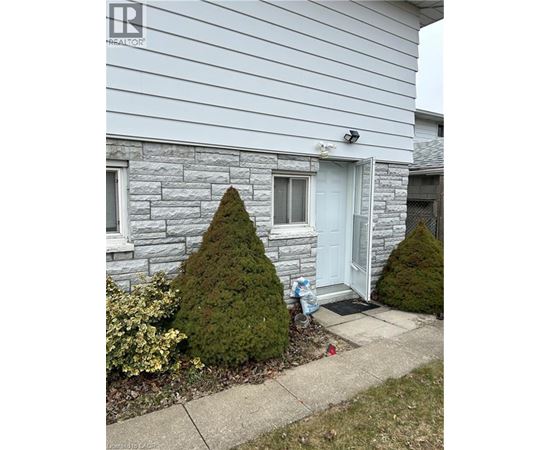 A house with a white door and a small tree in front of it.