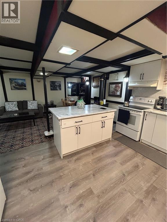 A kitchen with white cabinets and a wooden floor.