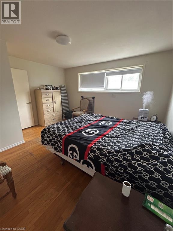A bedroom with a bed covered in a black and white patterned comforter.