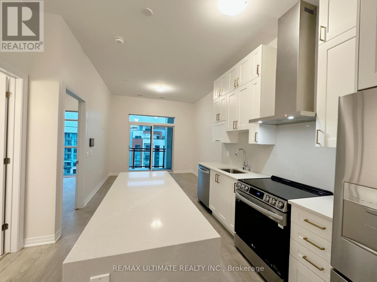 A modern kitchen with white cabinets and stainless steel appliances.
