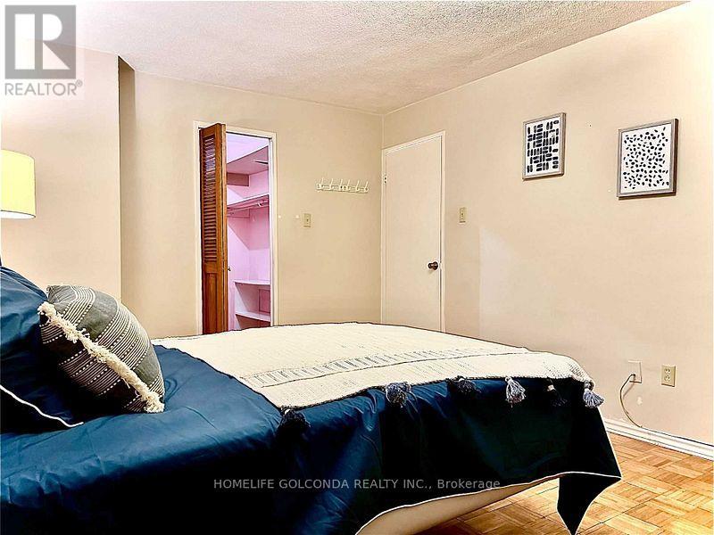 A bedroom with a bed covered in a blue sheet and pillow.