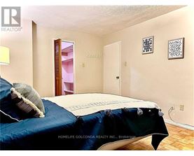 A bedroom with a bed covered in a blue sheet and pillow.