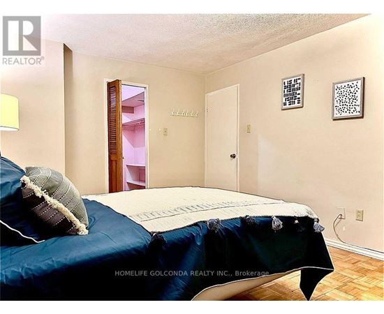 A bedroom with a bed covered in a blue sheet and pillow.