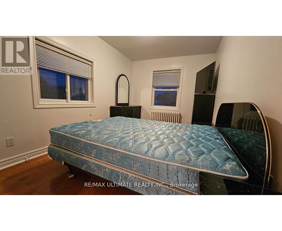 A bedroom with a bed, dresser, and mirror.