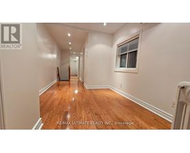 A long hallway with wood floors and white walls.