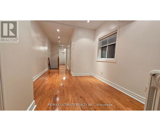 A long hallway with wood floors and white walls.