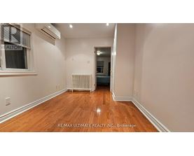 A room with wooden floors and a window with blinds.