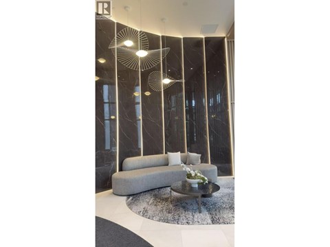 A modern living room with a grey sofa and a glass table.