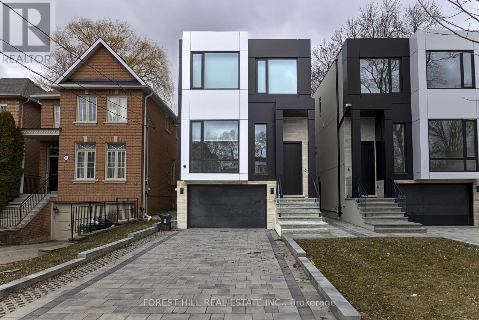 A modern house with a brick house in the background.