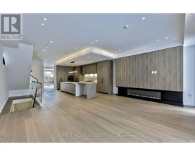 A spacious living room with wood paneling and a fireplace.