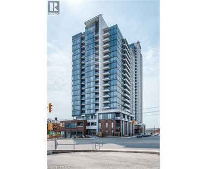 A modern multi-story building with a glass facade is under construction.