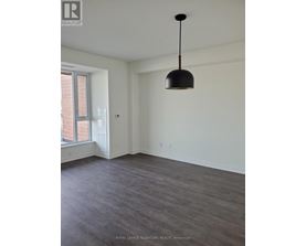A room with a grey floor and a black pendant light hanging from the ceiling.