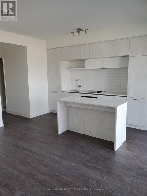 A white kitchen with a sink and a counter.