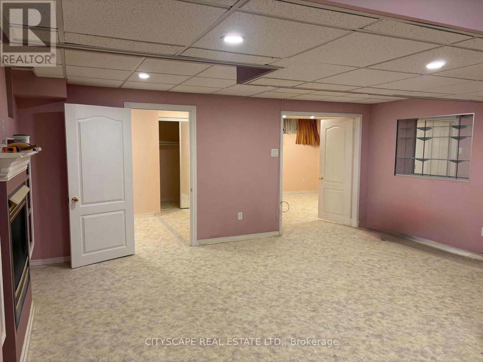 A room with pink walls and a carpeted floor.