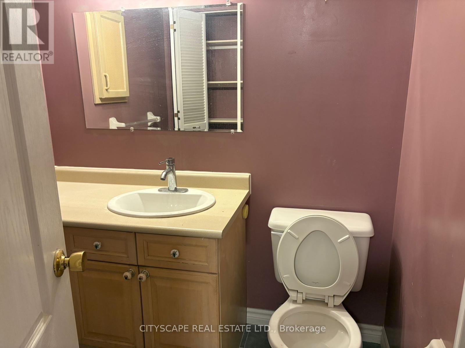 A white toilet sits next to a sink in a bathroom.
