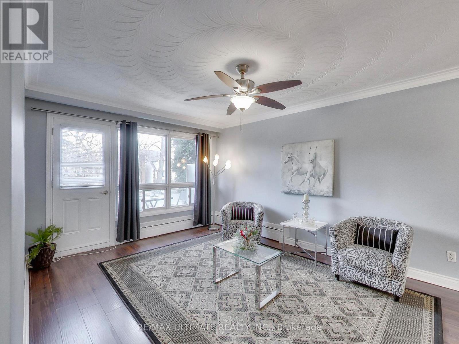 A living room with a glass table and two chairs.