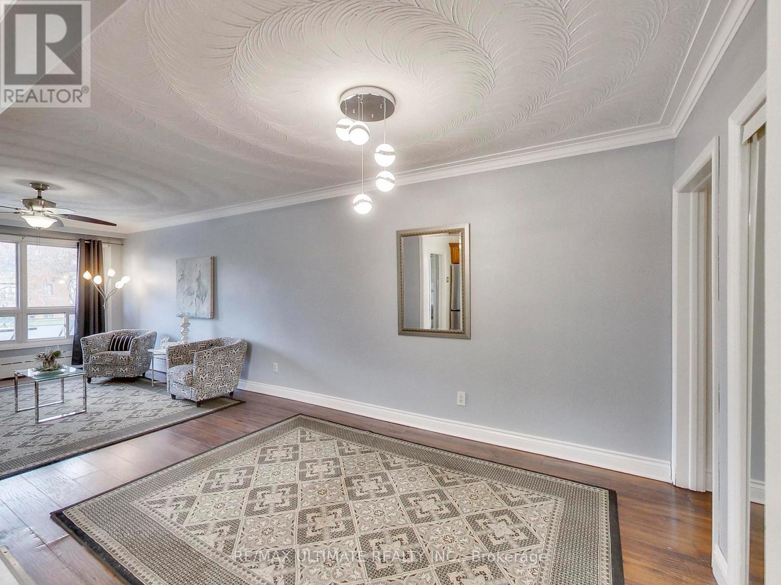 A spacious room with a rug on the floor and a mirror on the wall.