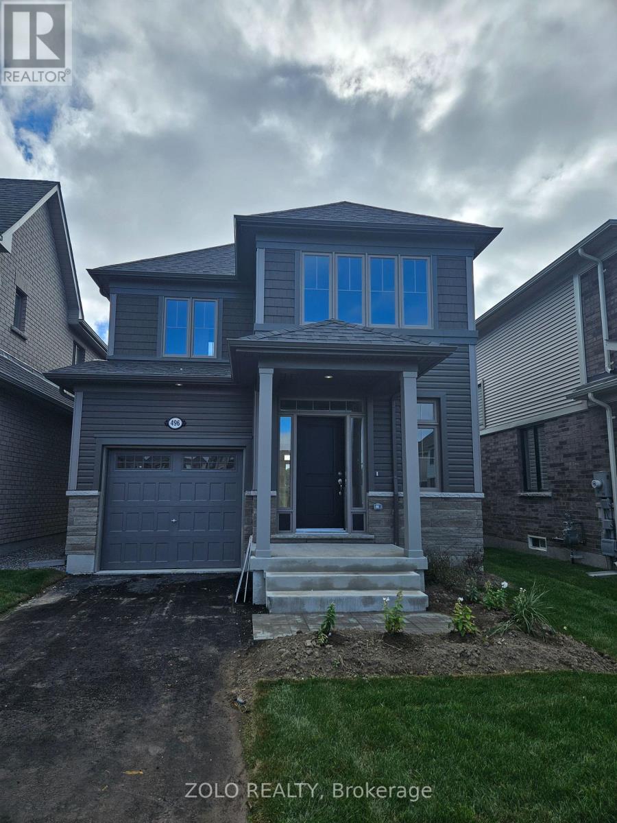 A house with a grey front yard and a garage door.