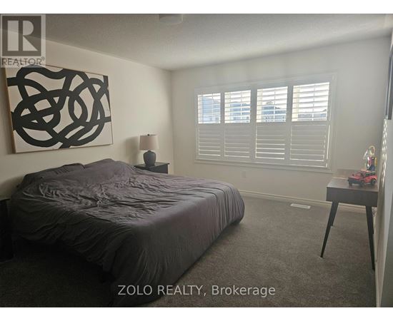 A bedroom with a large bed and a large abstract painting on the wall.