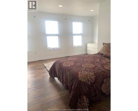A bedroom with a bed and a dresser.