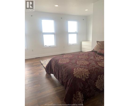A bedroom with a bed and a dresser.
