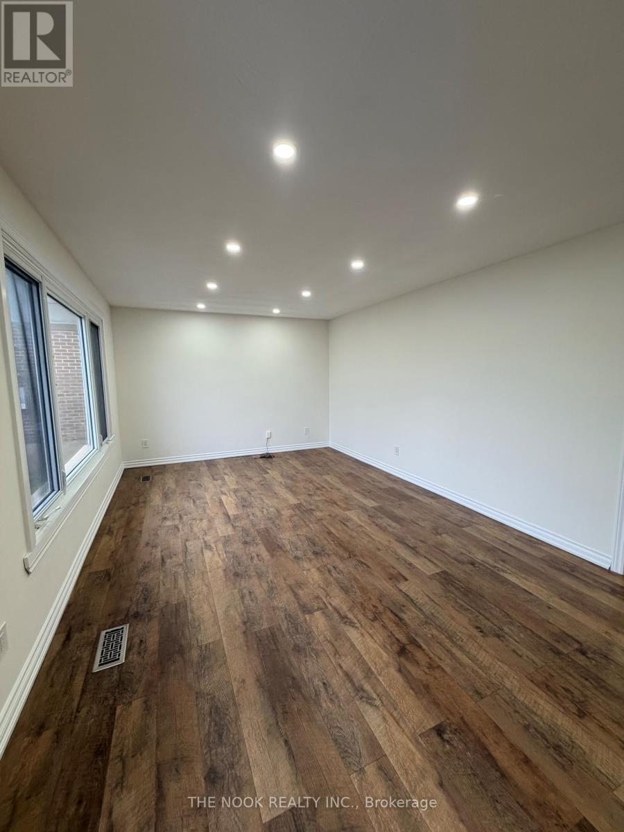 A room with wooden flooring and a window.