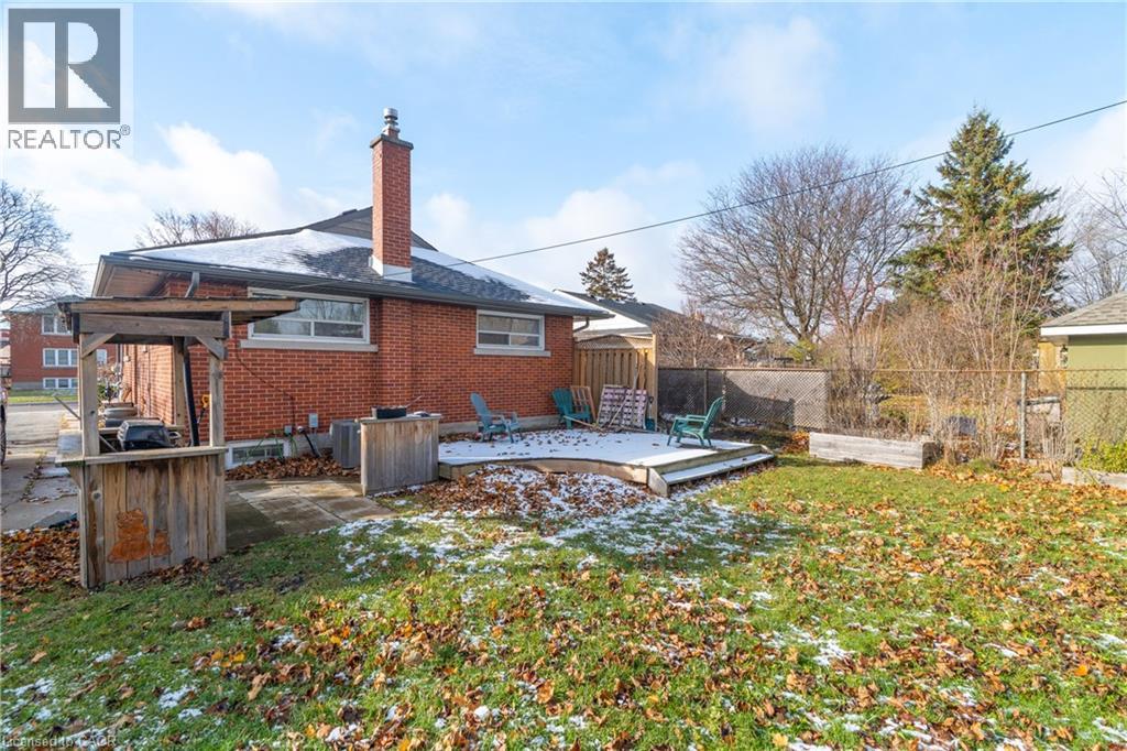 A house with a snow-covered ground and a brown brick exterior.