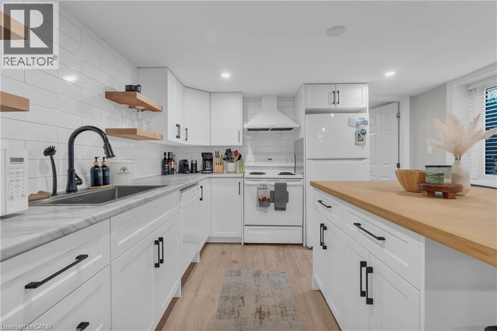 A modern kitchen with white cabinets and a wooden island.