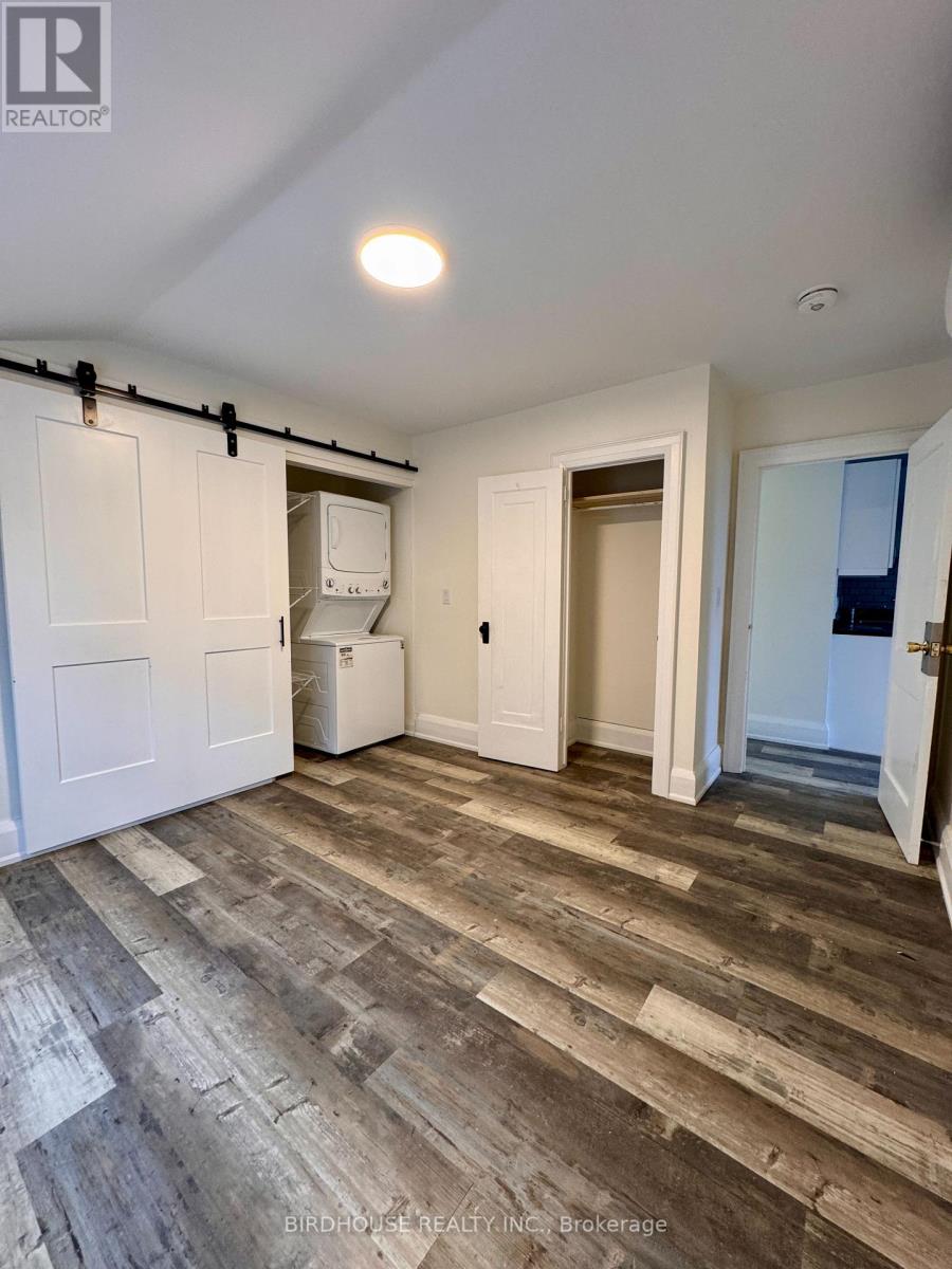 A room with wooden flooring and white walls.