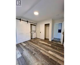 A room with wooden flooring and white walls.