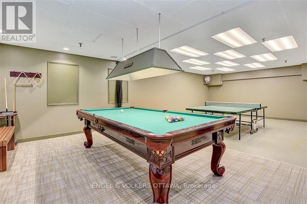 A pool table in a room with a light colored carpet.