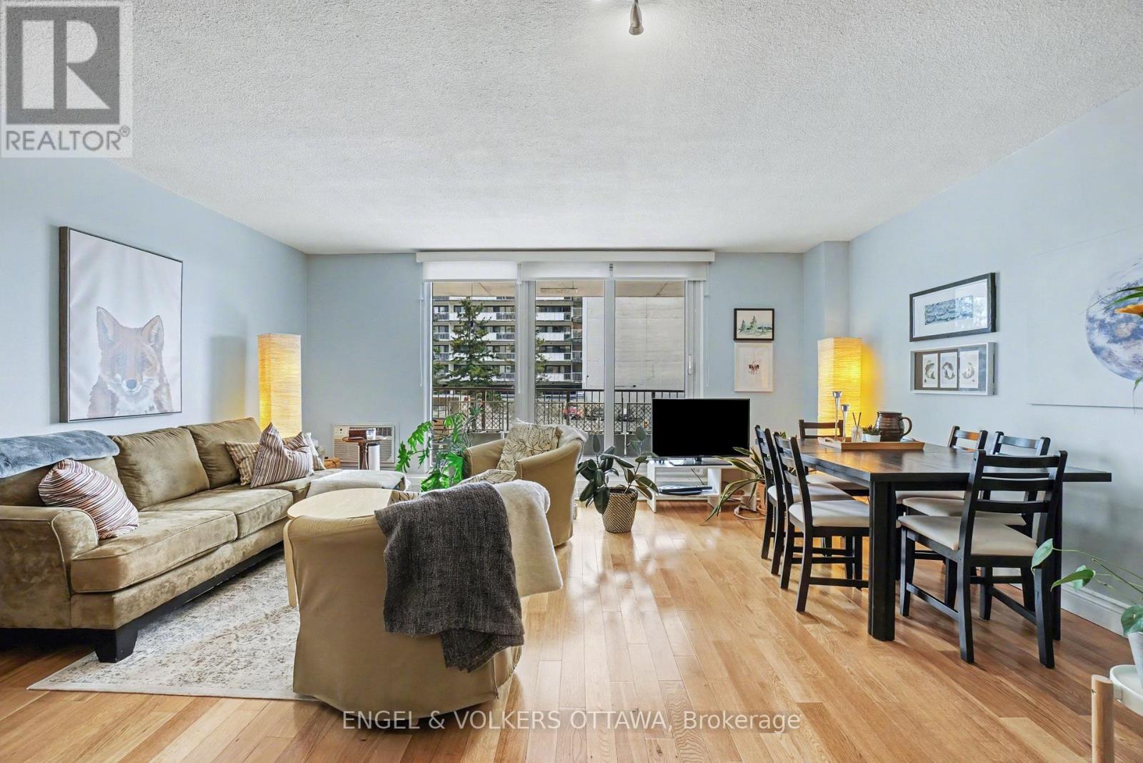 A living room with a couch, chairs, and a dining table.