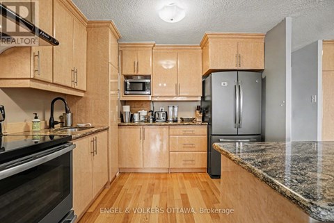 A kitchen with wooden cabinets and granite countertops.
