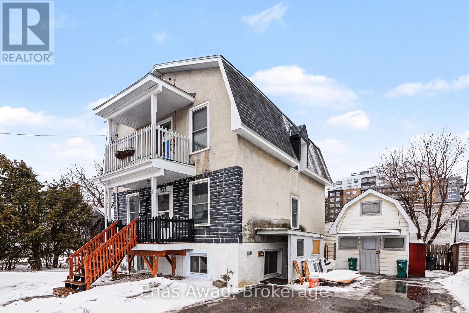 A house with a balcony and a red staircase is for sale.